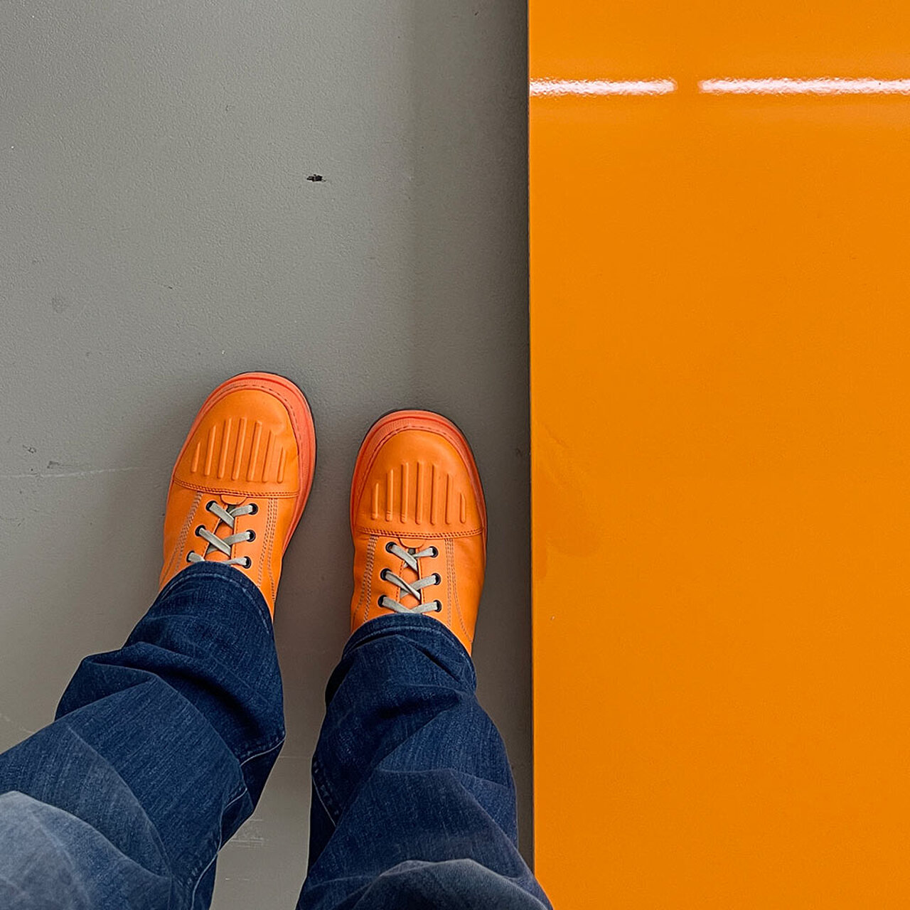 Orange Schuhe neben oranger Glasplatte
